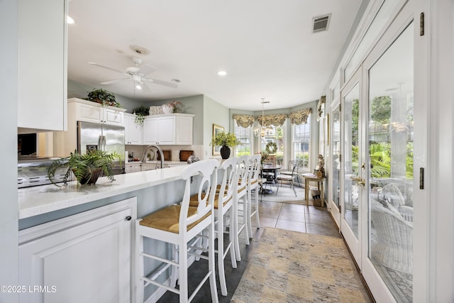2 Lenox Ln, Hilton Head Island, SC 29926 - kitchen featuring stainless steel fridge, white cabinetry, recessed lighting, a ceiling fan, and pendant lighting