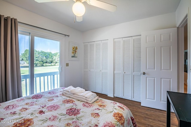 bedroom with dark hardwood / wood-style floors, access to outside, two closets, and ceiling fan