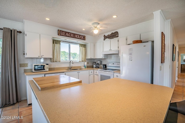 kitchen with sink, white appliances, white cabinets, and a textured ceiling