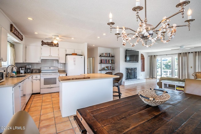 kitchen featuring white cabinetry, white appliances, sink, and a textured ceiling