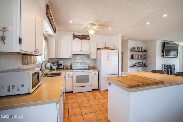 kitchen with sink, white appliances, white cabinetry, a textured ceiling, and light tile patterned flooring