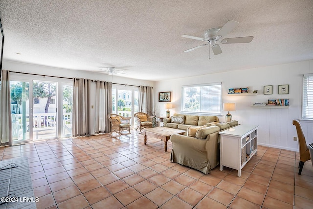 tiled living room with ceiling fan and a textured ceiling