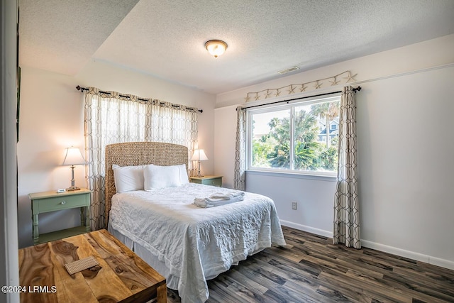 bedroom with dark hardwood / wood-style floors and a textured ceiling