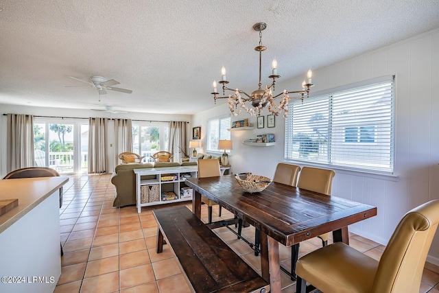 dining room featuring light tile patterned flooring, ceiling fan with notable chandelier, and a textured ceiling