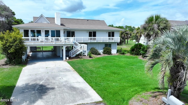 rear view of house featuring a carport and a yard