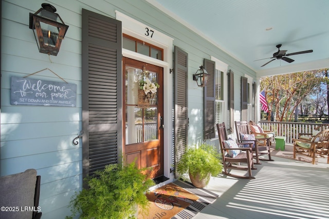 view of exterior entry with a porch and ceiling fan