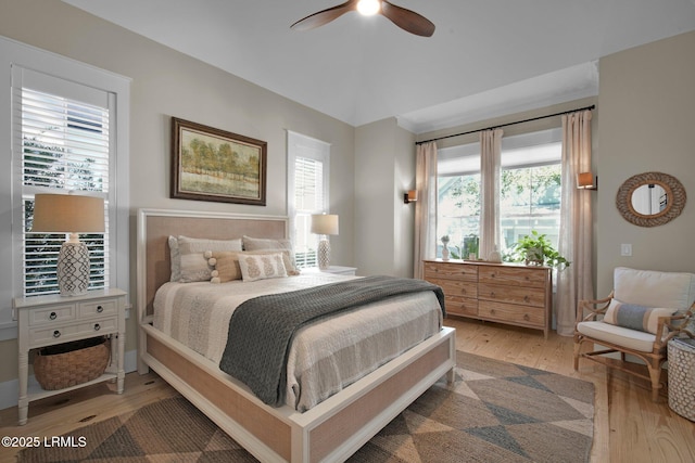 bedroom featuring hardwood / wood-style flooring, ceiling fan, and multiple windows