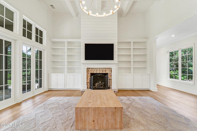 4 Wedgewood Cir, Bluffton, SC 29910 - unfurnished living room with wood finished floors, ornamental molding, a brick fireplace, a chandelier, and built in shelves