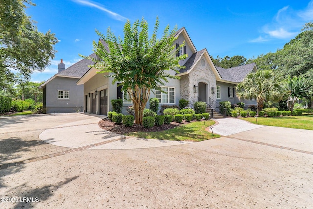 4 Wedgewood Cir, Bluffton, SC 29910 - view of front of home featuring concrete driveway, a chimney, stucco siding, and stone siding