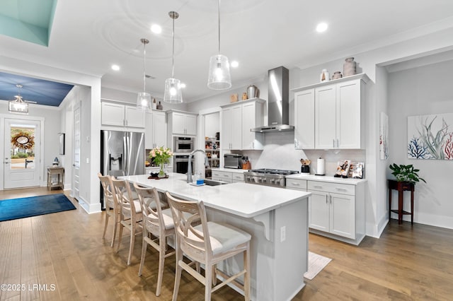 kitchen featuring white cabinetry, appliances with stainless steel finishes, sink, and wall chimney exhaust hood