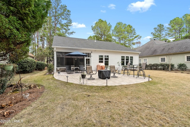 back of house featuring a yard, a patio, and a sunroom