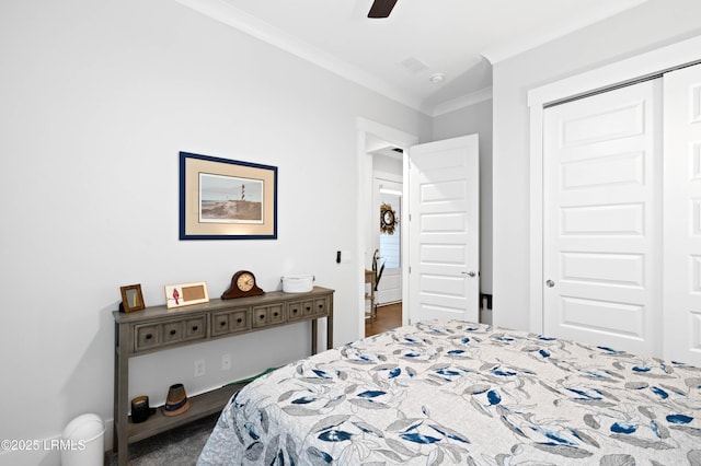 bedroom with crown molding, ceiling fan, and a closet