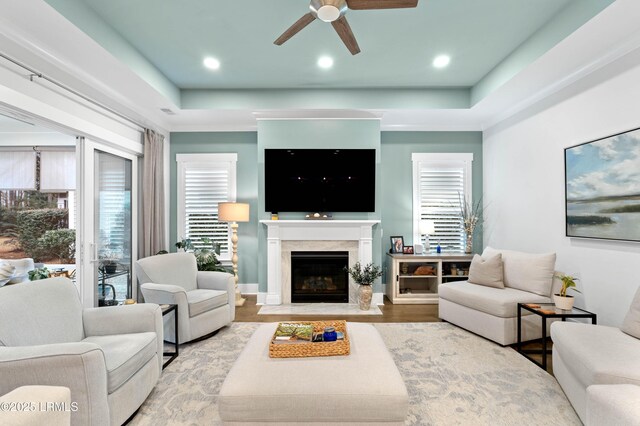 180 Alder Ln, Hardeeville, SC 29927 - living room featuring a healthy amount of sunlight, ceiling fan, a fireplace, and a tray ceiling