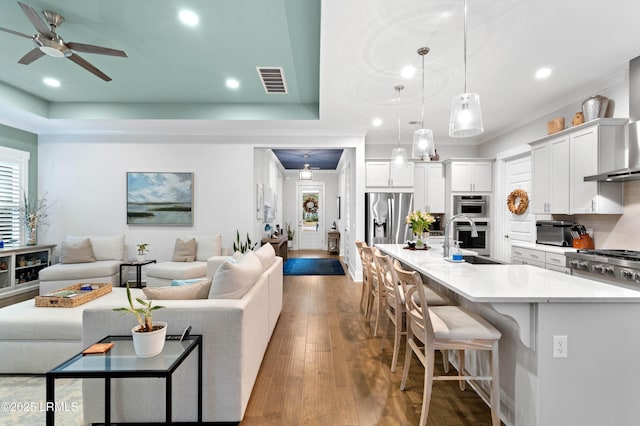 kitchen with appliances with stainless steel finishes, a breakfast bar, decorative light fixtures, sink, and white cabinets