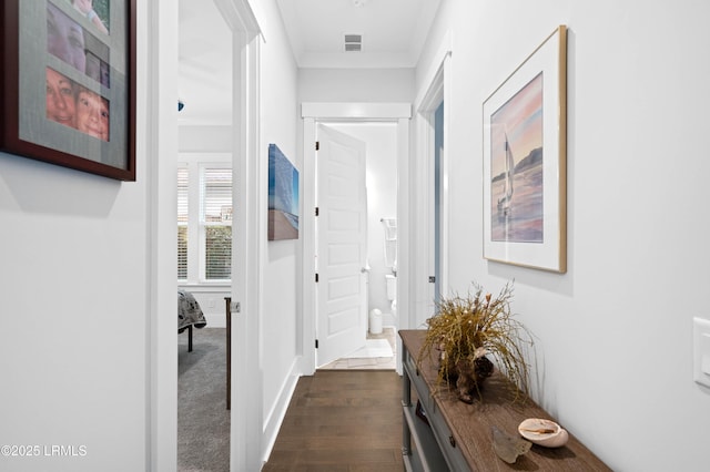 corridor featuring crown molding and dark hardwood / wood-style flooring