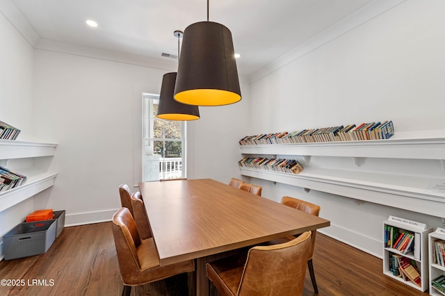 dining space featuring crown molding and dark hardwood / wood-style flooring