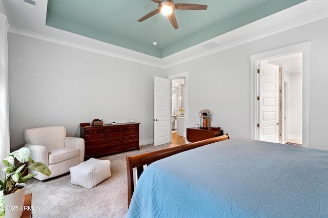 bedroom featuring a tray ceiling, ornamental molding, ceiling fan, and carpet flooring