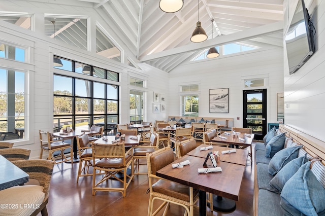 dining area featuring beam ceiling and high vaulted ceiling