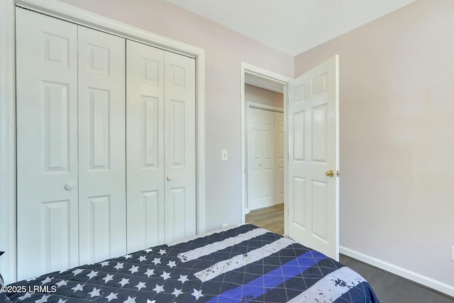 bedroom featuring a textured ceiling, a closet, and dark hardwood / wood-style floors