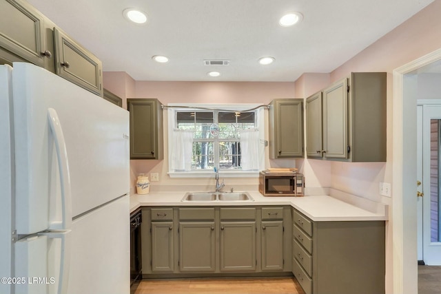 kitchen with sink, black dishwasher, white refrigerator, and light hardwood / wood-style floors