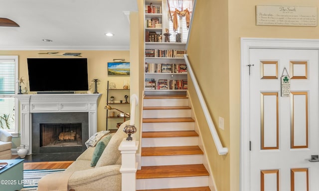 8 Battery Point Ln, Beaufort, SC 29902 - stairs with ornamental molding, a fireplace with flush hearth, and wood finished floors