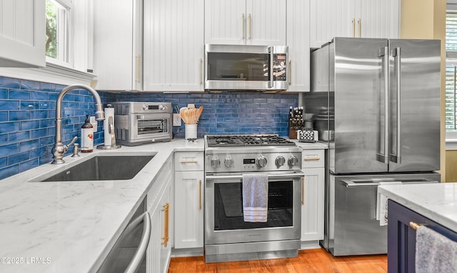 8 Battery Point Ln, Beaufort, SC 29902 - kitchen with premium appliances, tasteful backsplash, and white cabinetry