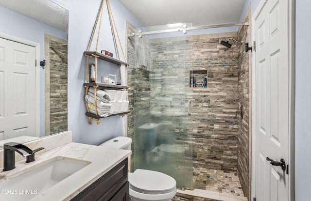 bathroom featuring vanity, an enclosed shower, and toilet