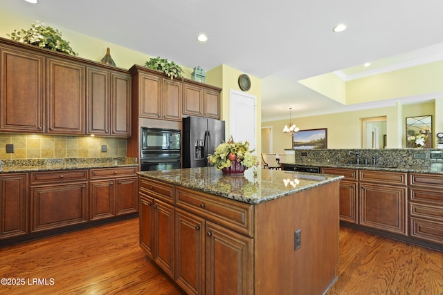 19 Lynnfield Pl, Bluffton, SC 29910 - kitchen with black appliances, a kitchen island, ornamental molding, dark wood-style floors, and tasteful backsplash