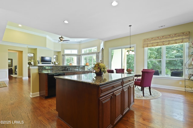 19 Lynnfield Pl, Bluffton, SC 29910 - kitchen featuring black dishwasher, a center island, dark wood-type flooring, crown molding, and dark stone counters