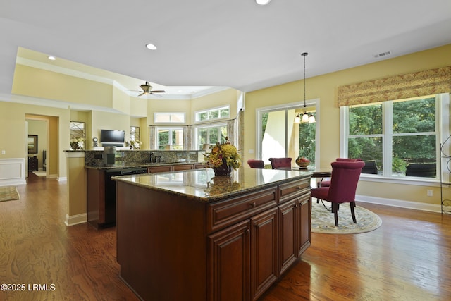 19 Lynnfield Pl, Bluffton, SC 29910 - kitchen with dishwashing machine, dark wood-style floors, crown molding, a kitchen island, and dark stone counters