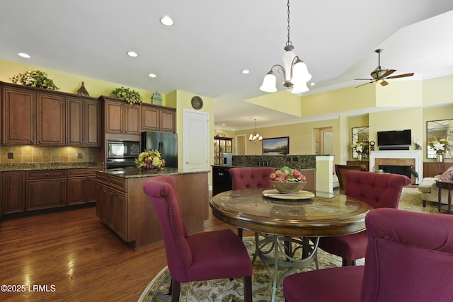 19 Lynnfield Pl, Bluffton, SC 29910 - dining area with a chandelier, dark wood-style floors, a tile fireplace, crown molding, and a ceiling fan