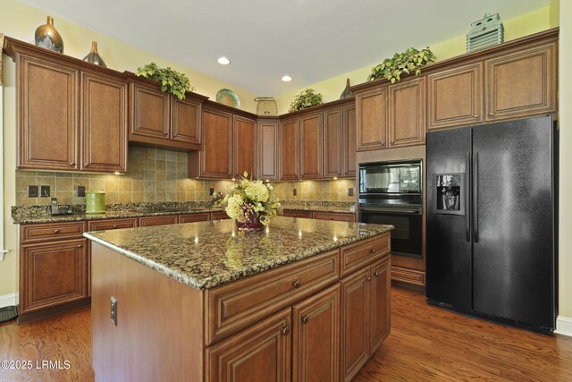 19 Lynnfield Pl, Bluffton, SC 29910 - kitchen featuring black appliances, dark wood-style flooring, dark stone countertops, tasteful backsplash, and recessed lighting
