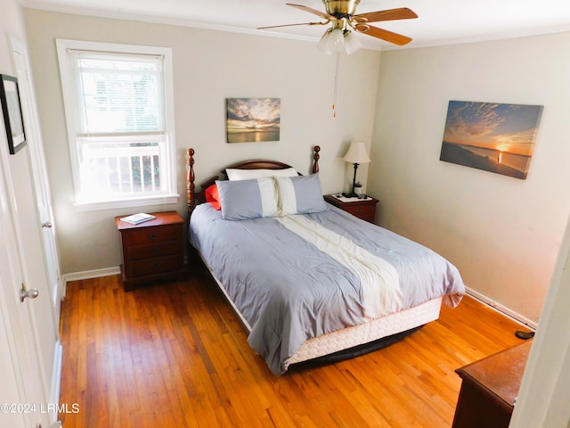 bedroom with crown molding, hardwood / wood-style floors, and ceiling fan