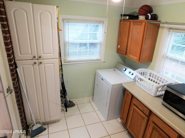 washroom featuring cabinets, washer / clothes dryer, and light tile patterned floors