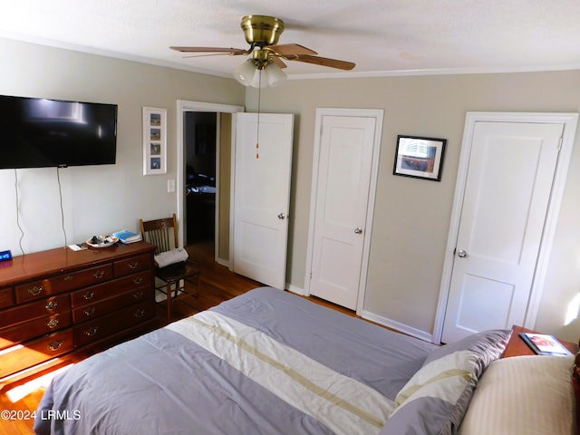 bedroom featuring hardwood / wood-style flooring, ceiling fan, and crown molding