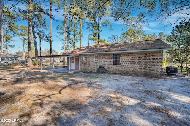 back of house with a carport and central AC unit