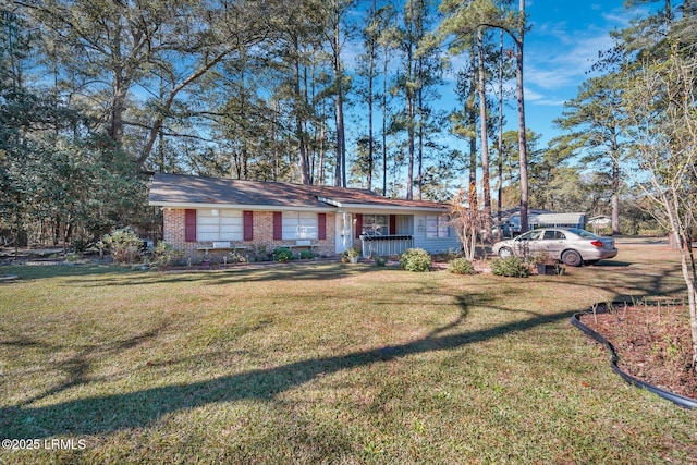 ranch-style home featuring covered porch and a front lawn