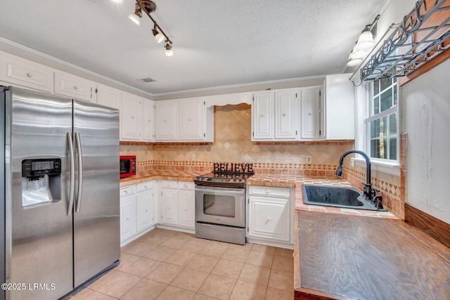 kitchen featuring stainless steel appliances, white cabinetry, sink, and light tile patterned floors