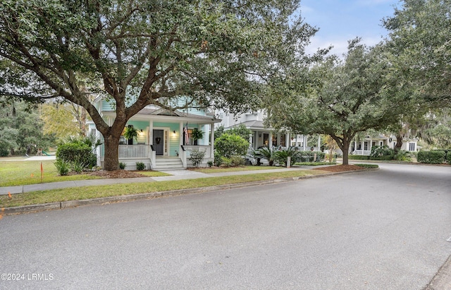 view of property hidden behind natural elements featuring a porch