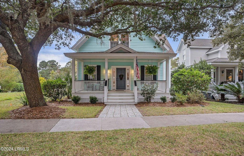 bungalow-style home with a front lawn and a porch