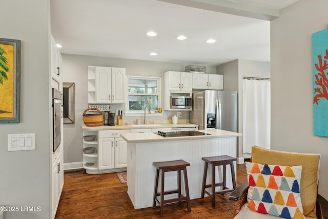 kitchen featuring white cabinets, a center island, open shelves, and appliances with stainless steel finishes