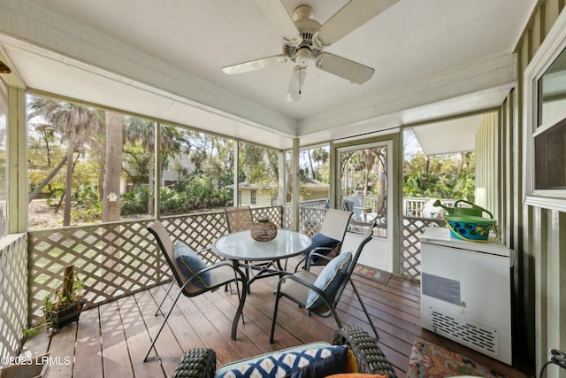 sunroom / solarium featuring outdoor dining space, ceiling fan, and heating unit