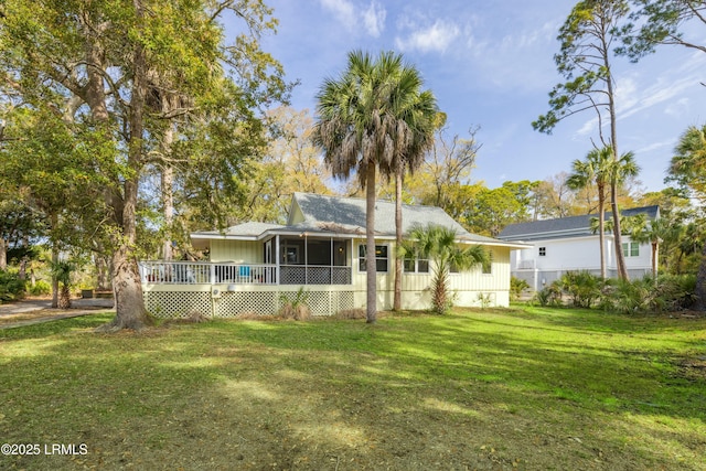 rear view of property featuring a yard and a deck