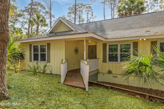 view of front facade featuring roof with shingles, crawl space, and a front lawn