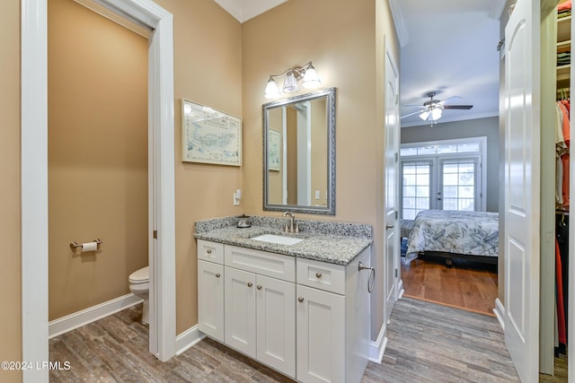 bathroom featuring vanity, hardwood / wood-style floors, ceiling fan, and toilet