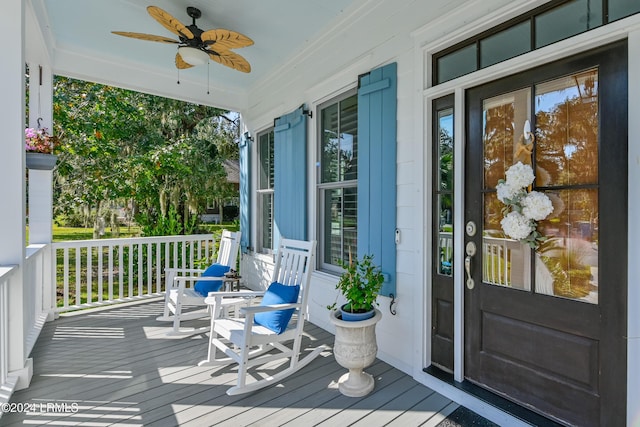 view of exterior entry with ceiling fan and a porch