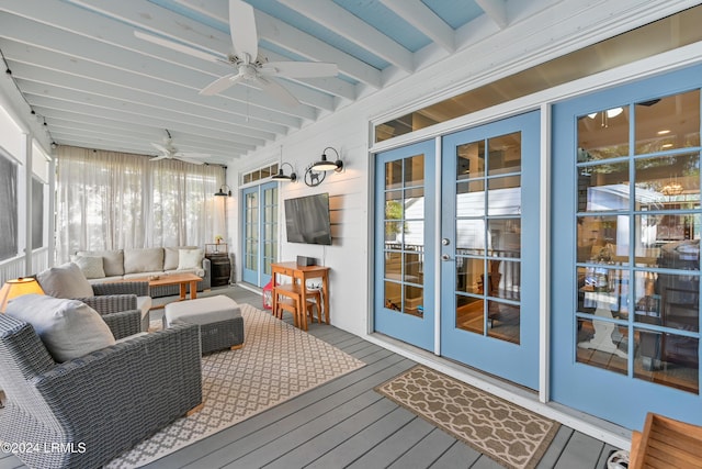 sunroom with ceiling fan and beam ceiling