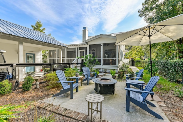 view of patio / terrace with a sunroom and a fire pit