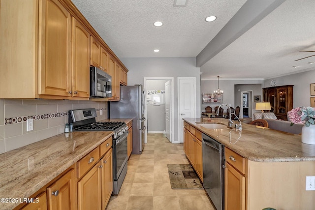 kitchen featuring light stone countertops, stainless steel appliances, an inviting chandelier, and a sink