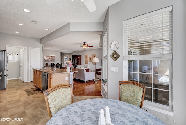 dining space with recessed lighting, ceiling fan with notable chandelier, visible vents, and a textured ceiling